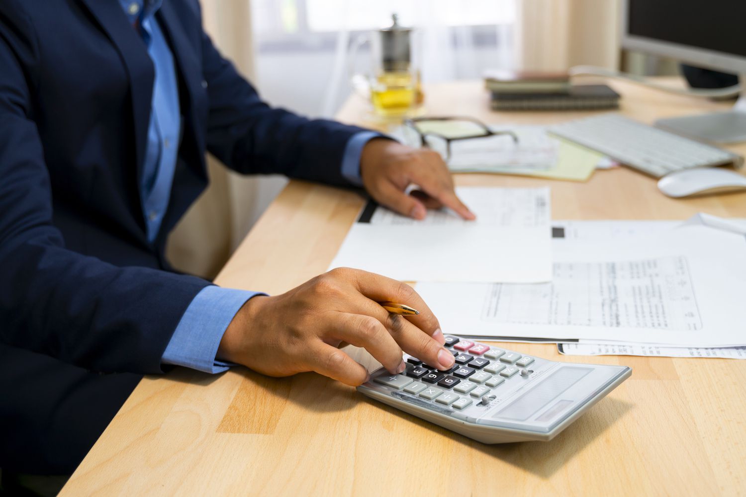A businessman using a calculator to calculate the numbers.