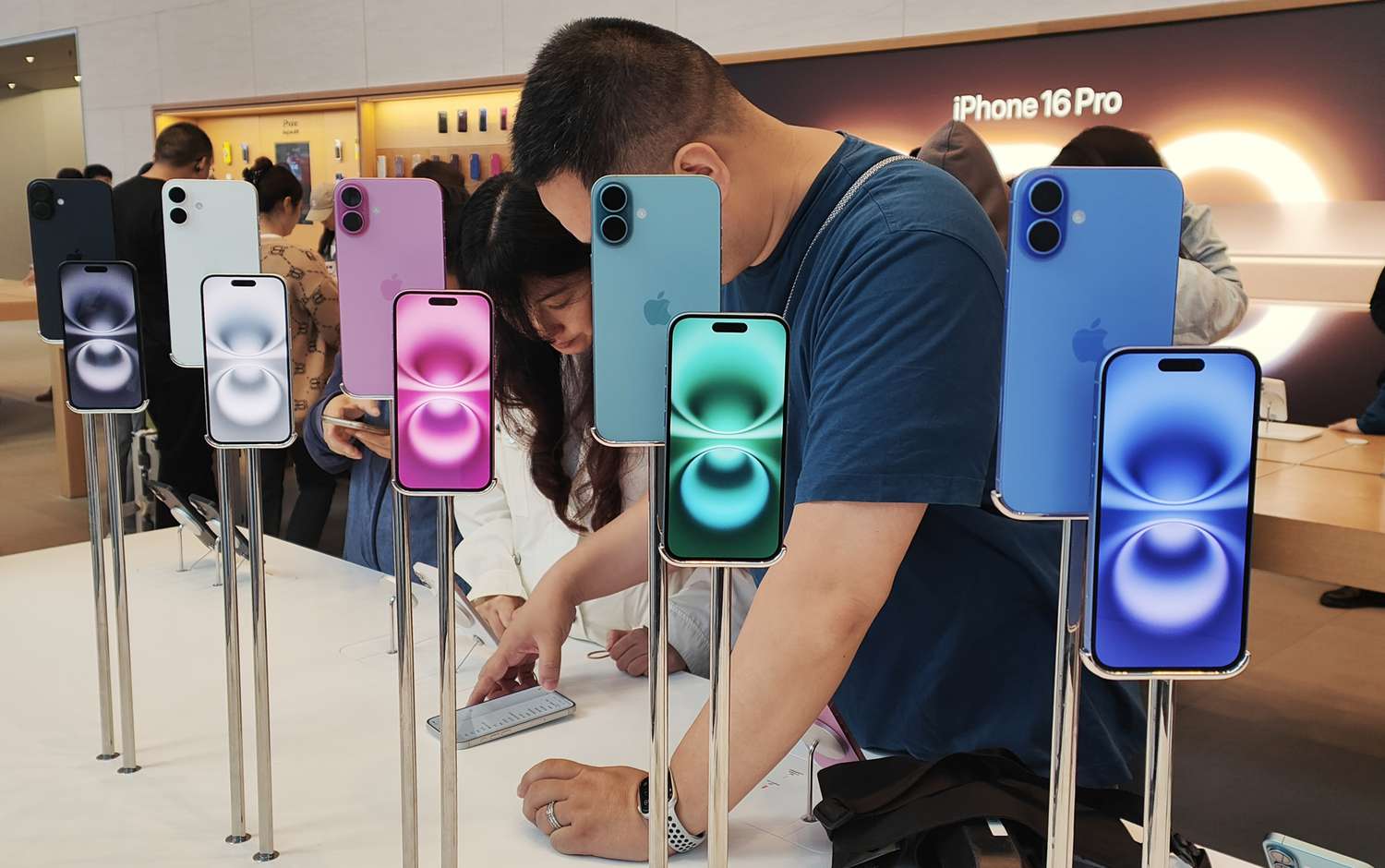 Customers experience the iPhone 16 series at Apple's flagship store in Shanghai, China, October 15, 2024