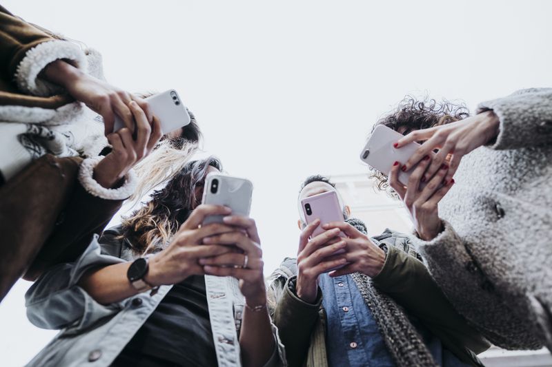 Group of friends in the street with smartphones
