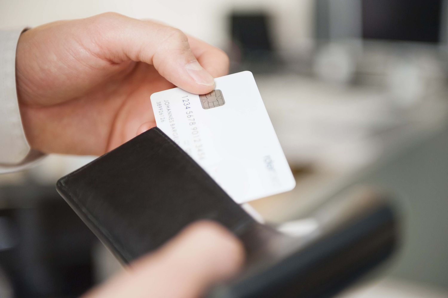 Hands of man holding wallet and cash-back debit card
