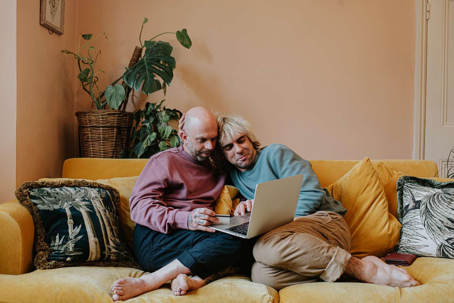 Couple sitting closely on a couch looking at a laptop