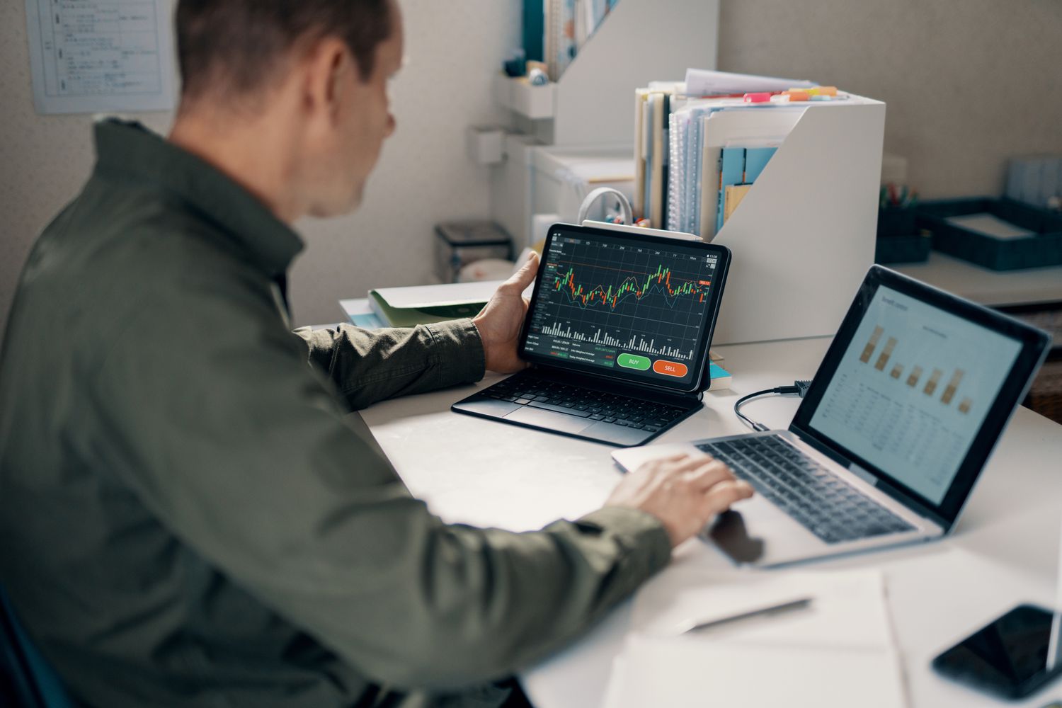 A day trader uses two laptops to analyze the price and volume of a stock in hopes of executing a positive trade.