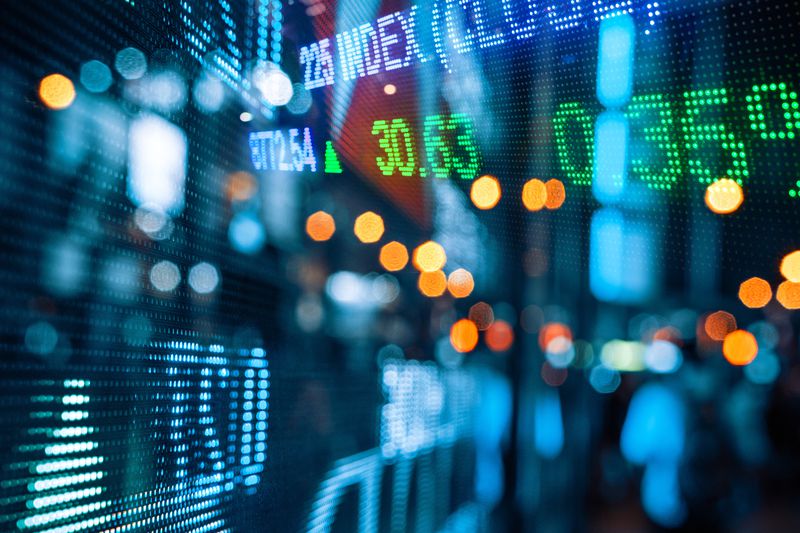 Colorful stock market quotes display reflected on glass