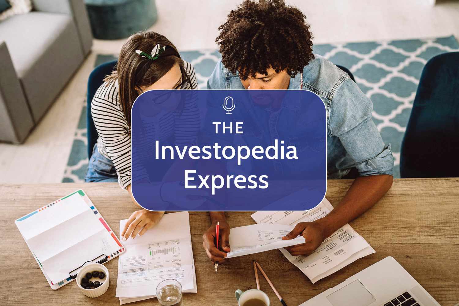 Two people sitting at a table and looking at their finances on paper