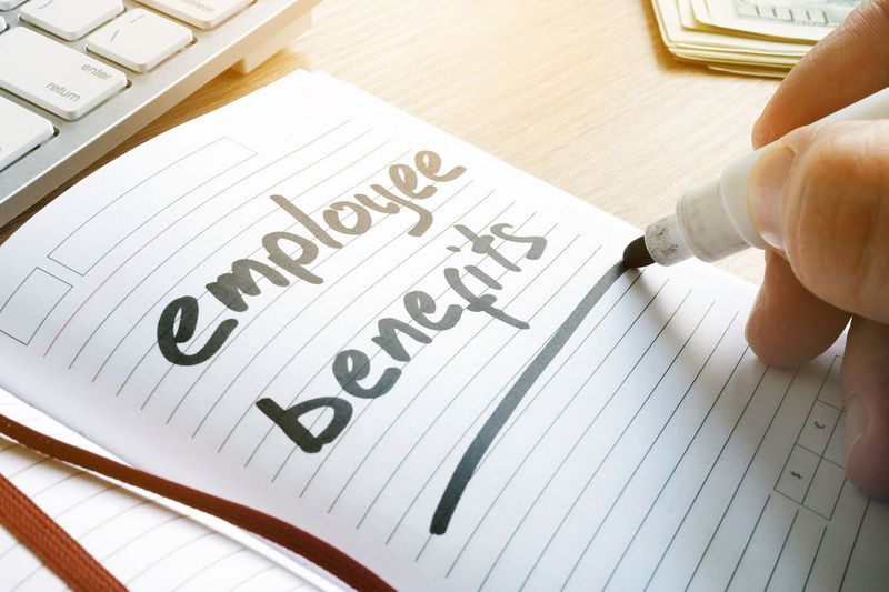 Hand Is Writing Employee Benefits in a Note