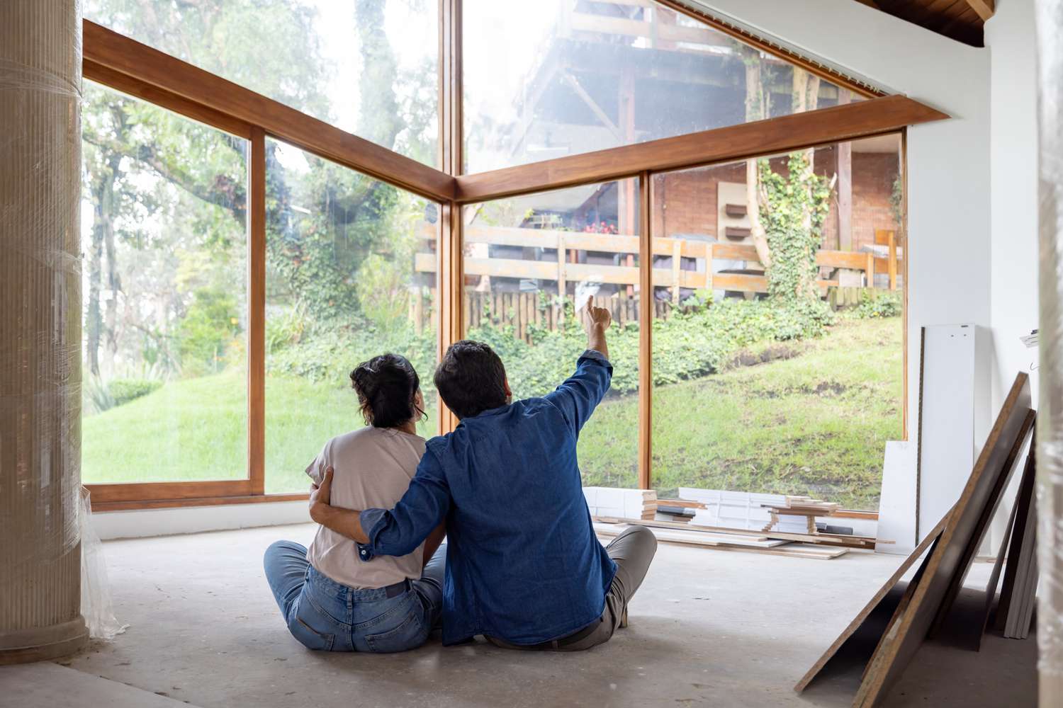 A couple sitting on the floor and planning the remodel of the house they shared equity together.