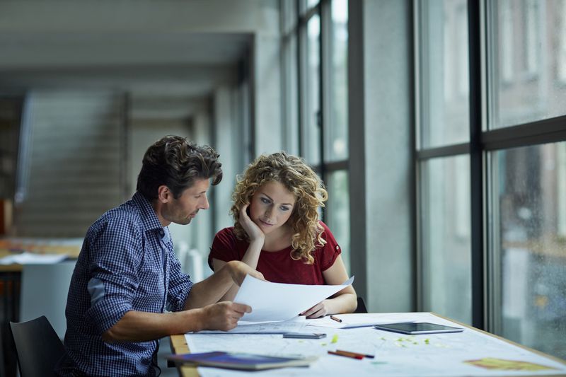 Two people review documents.