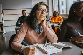 Mature female student sitting with friends in Grad School