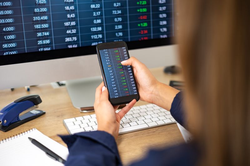 An options trader checks contract prices and places an order on a cell phone.