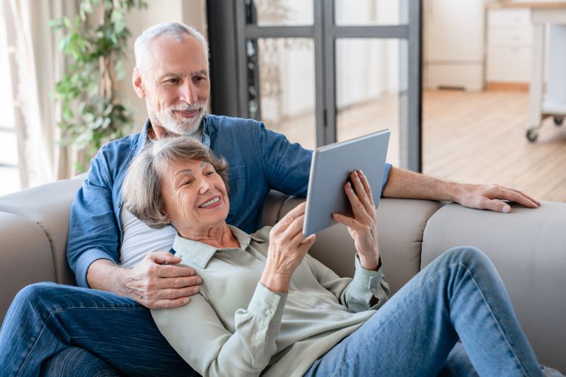 Couple sitting on a couch with a tablet