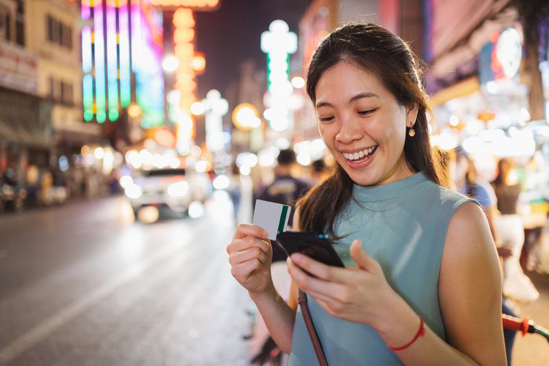 Asian Millennial women using crypto wallet paying and Mobile banking investment using mobile and credit card with happy emotion 