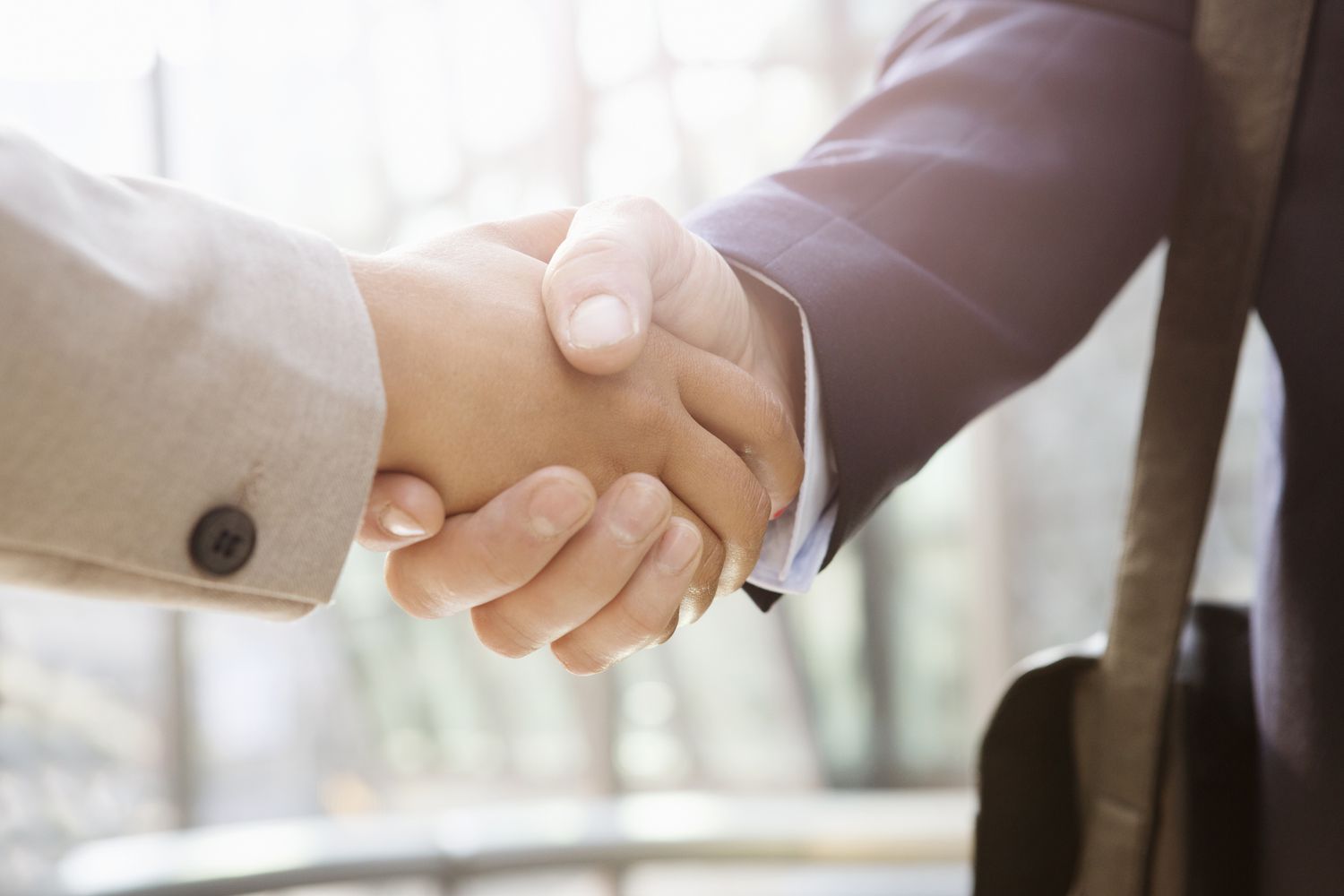 Businessman shakes hand of businesswoman.