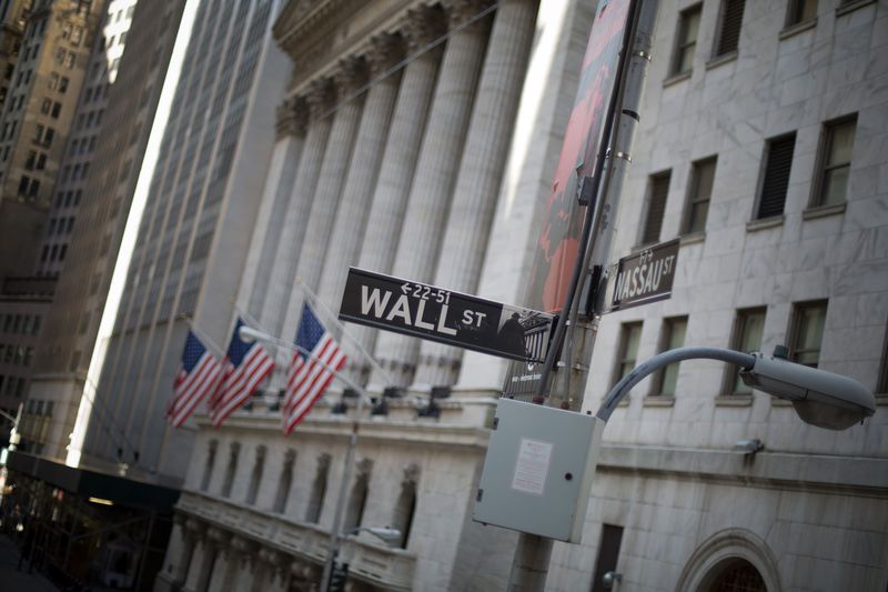 A Wall Street sign appears at a cross street in front of the New York Stock Exchange.