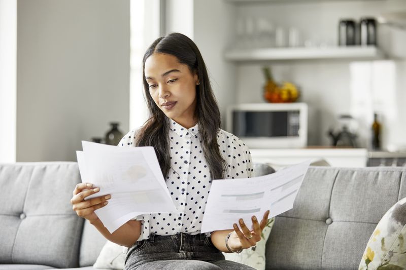 A woman reviews financial documents.