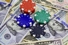 A stock image of poker chips sitting on top of US dollars. 