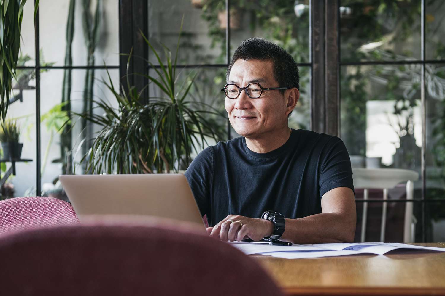 Smiling Chinese Man Working on Laptop at Home