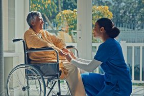 caregiver holds hands of elderly patient