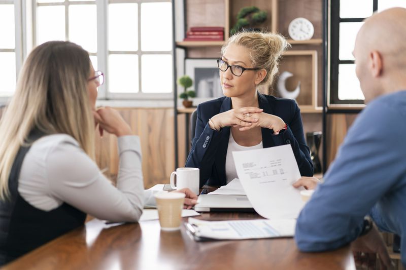 Couple talking with a lawyer in an office meeting