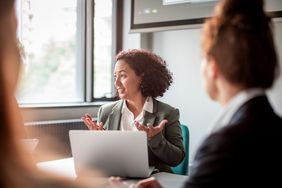 Close up of a woman in a group of business people having a meeting in a conference room