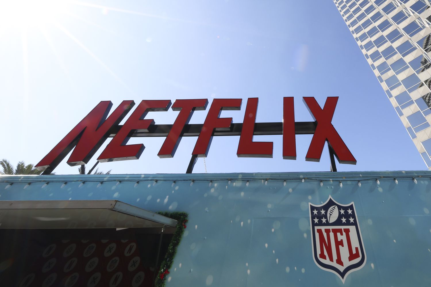 The red Netflix logo is seen on a sign above the NFL logo, with blue sky in the background.