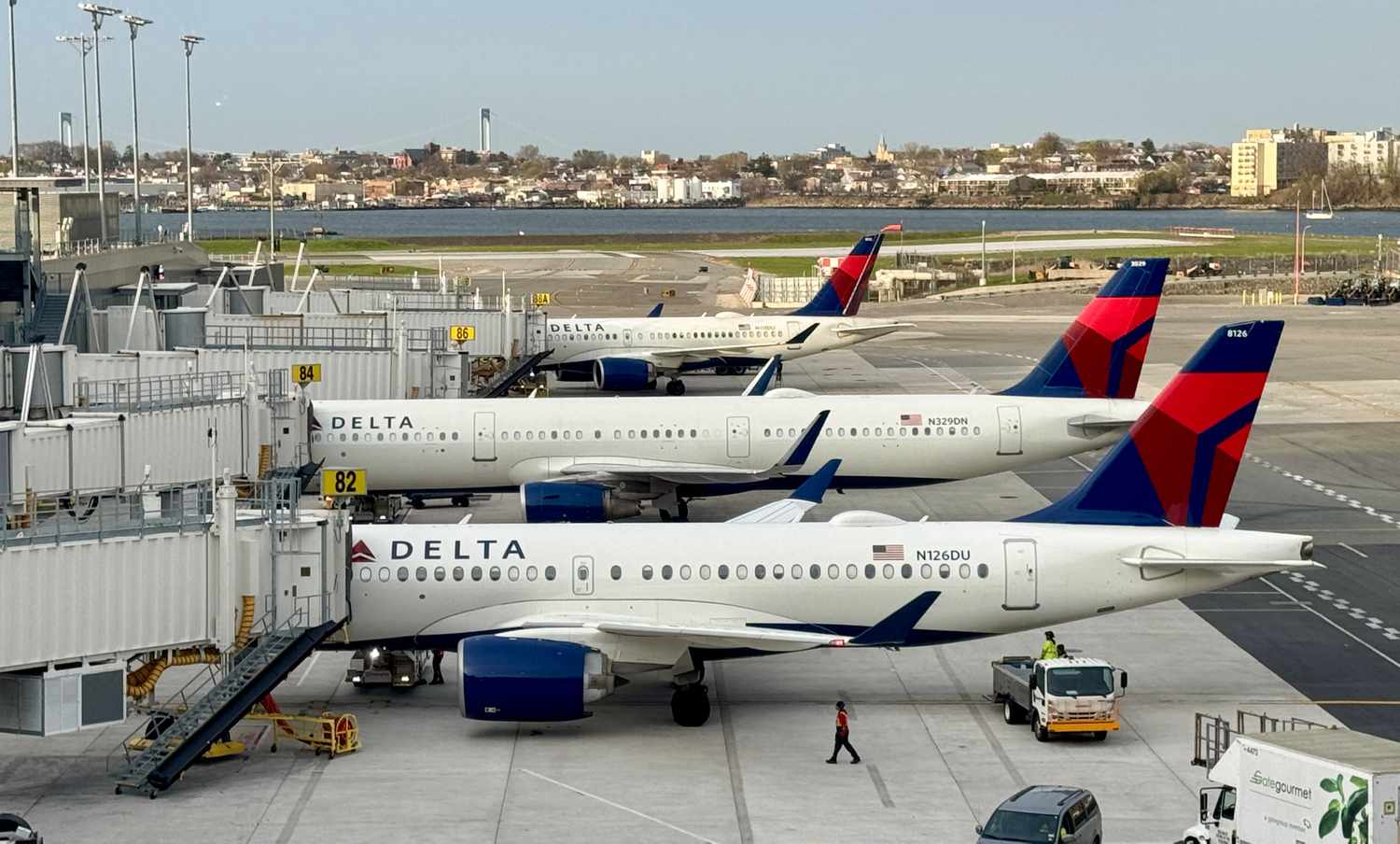 Three Delta Air Lines planes are seen next to an airport.