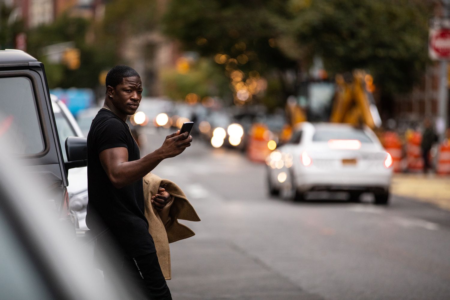 Man with phone in his hand, waiting for a car service.