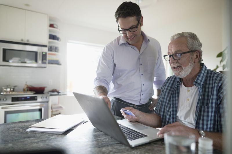 Older man and younger man looking at laptop