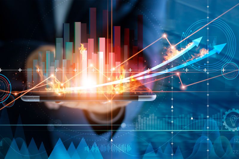 digital image of bar graphs and arrows going up over a midsection of a person using a tablet