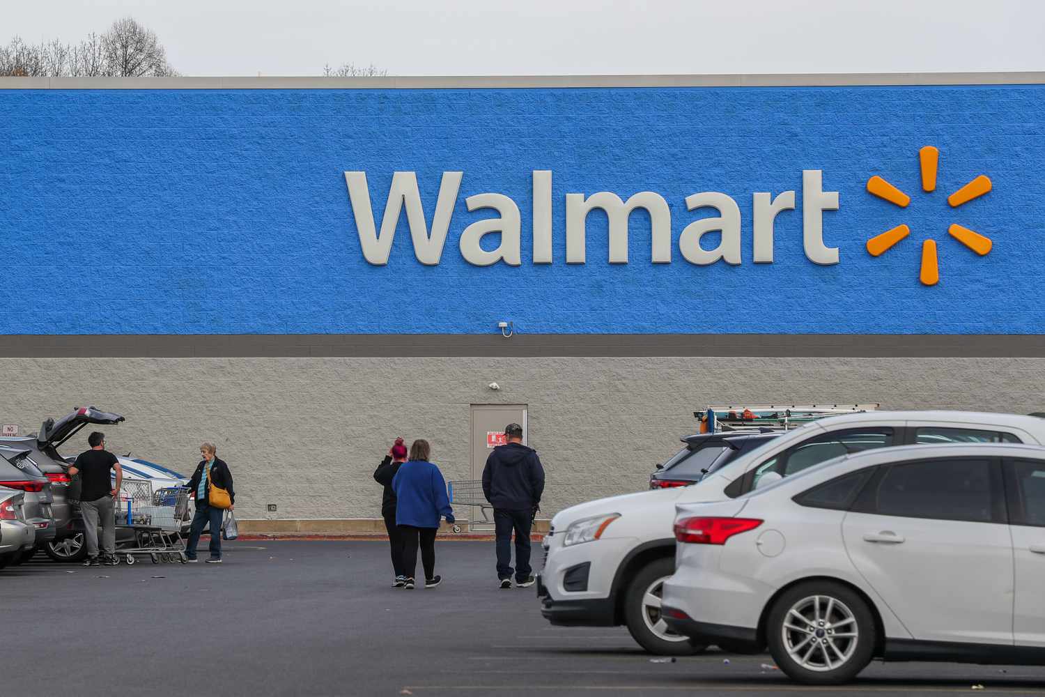 People and cars are seen outside of a Walmart store
