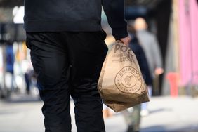 A person carries Chipotle bags in New York City. 