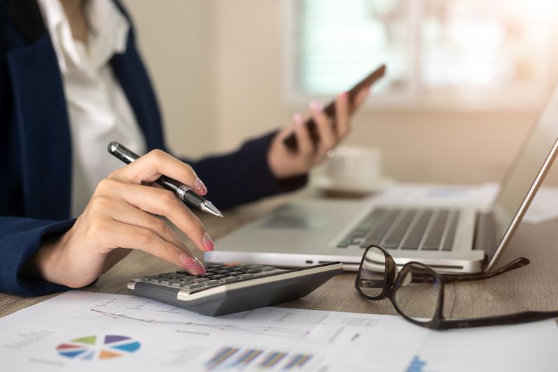 Close up of female accountant or banker making calculations. Savings, finances and economy concept