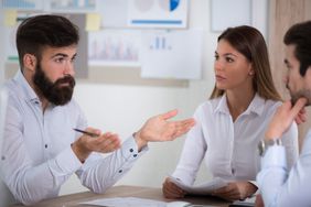 Three people sitting and discussing about credit repairing at an agency