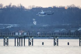 A helicopter flies near the crash site of the American Airlines plane on the Potomac River