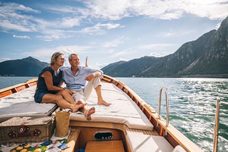 Elderly couple sitting on a sailboat in a large lake
